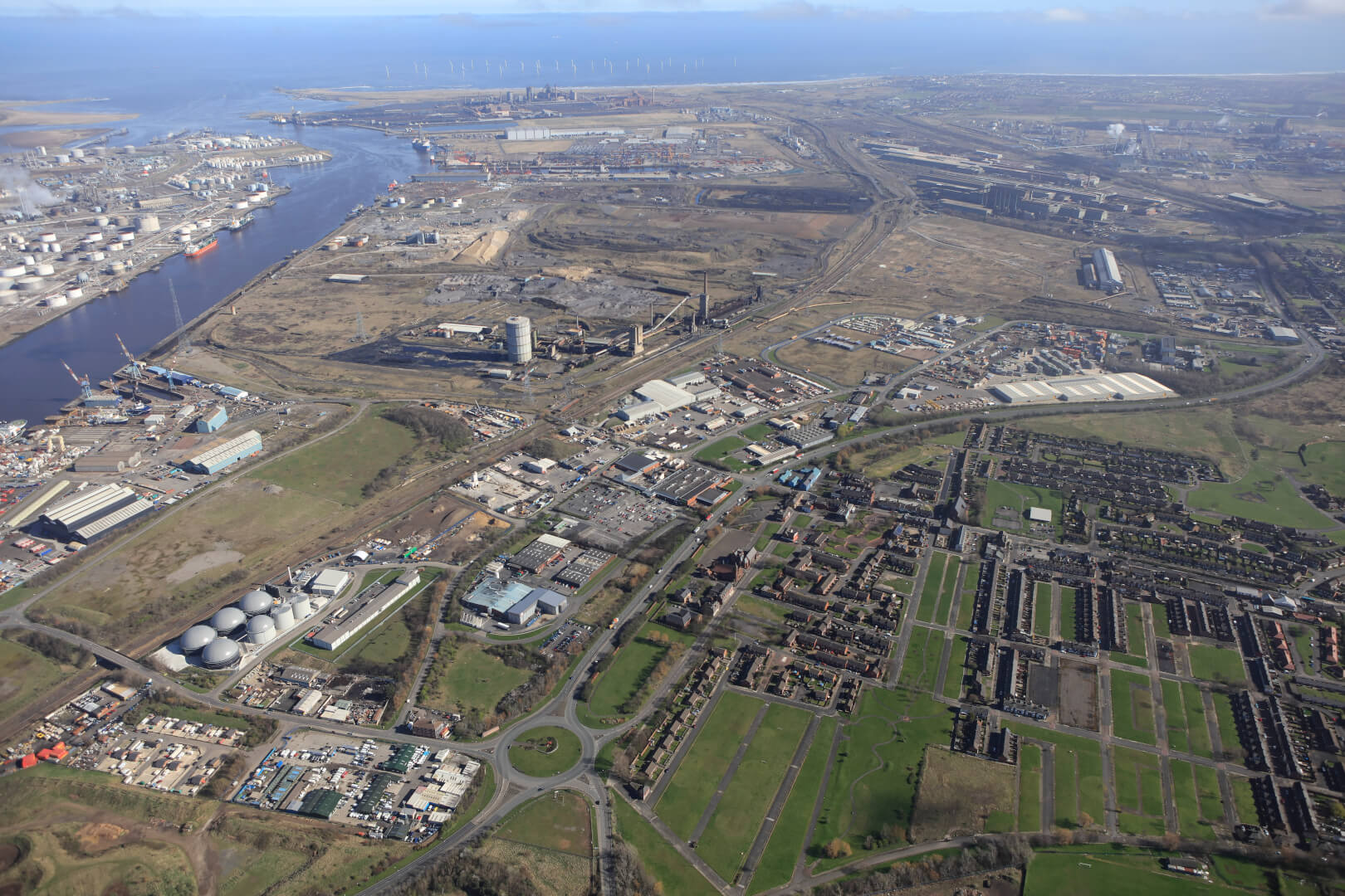 Aerial view of industrial site and port with residential area in foreground